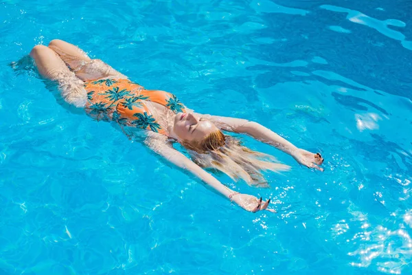 Havuzda güzel, sarışın, Avrupalı bir kadın, tatil ve tatil konsepti. Sıcak yaz zamanı