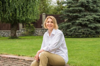 Parkta orta yaşlı güzel bir kadın. Sokaktaki hoş bir bayanın portresi. 50- 55 'ler yaşam tarzı