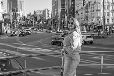 Baharda şehir caddesinde yürüyen şık bir kadın. Gündelik moda, moda tarzı. Artı boyut modeli. Şehrin sokaklarında yürüyen mutlu şişman kadın