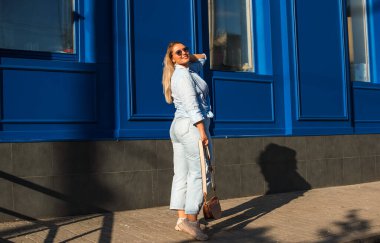 Baharda şehir caddesinde yürüyen şık bir kadın. Gündelik moda, moda tarzı. Artı boyut modeli. Şehrin sokaklarında yürüyen mutlu şişman kadın