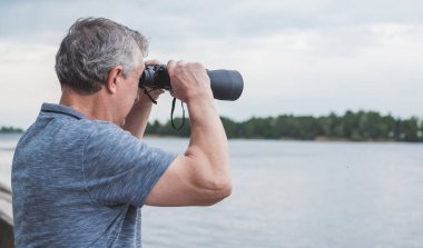  Dürbünle bakan Avrupalı Olgun Adam. Hobi ve eğlence konsepti
