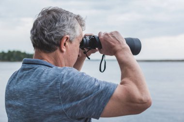  Dürbünle bakan Avrupalı Olgun Adam. Hobi ve eğlence konsepti