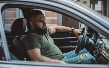 Arabadaki sakallı adamların portresi, yaklaşın. Otomobilli adam. Hobi kavramı, arabalar.