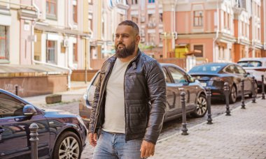 Büyük Avrupalı yarı Arap bir adam, deri ceket giyiyor, yakışıklı bir adamın portresini çiziyor.