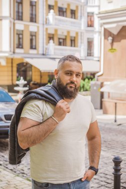 Büyük Avrupalı yarı Arap bir adam, deri ceket giyiyor, yakışıklı bir adamın portresini çiziyor.