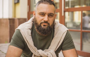 Kıyafet modası, yakışıklı bir adamın portresi. Şık tişörtlü, kot pantolonlu Avrupalı yarı Arap erkekler.