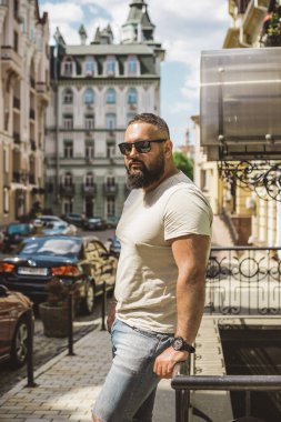 Kıyafet modası, yakışıklı bir adamın portresi. Şık tişörtlü, kot pantolonlu Avrupalı yarı Arap erkekler.