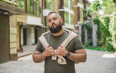 Kıyafet modası, yakışıklı bir adamın portresi. Şık tişörtlü, kot pantolonlu Avrupalı yarı Arap erkekler.