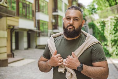 Kıyafet modası, yakışıklı bir adamın portresi. Şık tişörtlü, kot pantolonlu Avrupalı yarı Arap erkekler.