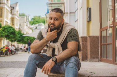 Kıyafet modası, yakışıklı bir adamın portresi. Şık tişörtlü, kot pantolonlu Avrupalı yarı Arap erkekler.