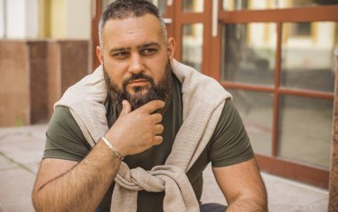 Kıyafet modası, yakışıklı bir adamın portresi. Şık tişörtlü, kot pantolonlu Avrupalı yarı Arap erkekler.