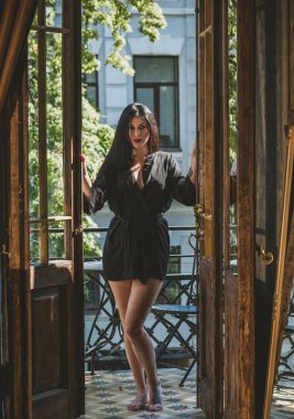 Siyah cüppeli bir kadın balkonda eski moda bir iç mekanda, şehvetli bir kadın.