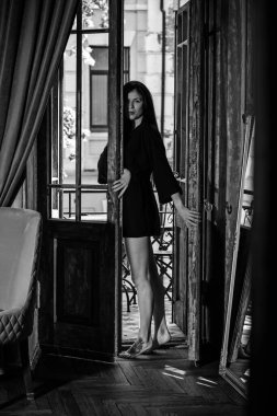 Siyah cüppeli bir kadın balkonda eski moda bir iç mekanda, şehvetli bir kadın.