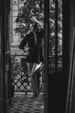 Siyah cüppeli bir kadın balkonda eski moda bir iç mekanda, şehvetli bir kadın.