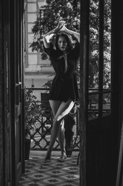 Siyah cüppeli bir kadın balkonda eski moda bir iç mekanda, şehvetli bir kadın.