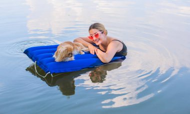 Sahibi ile birlikte doğada bir su yatağında küçük altın bir köpek. Evcil hayvan davranışı kavramı