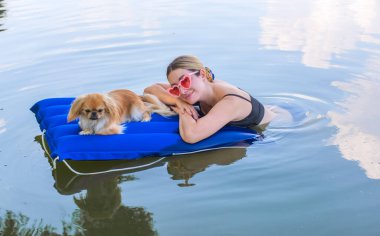 Sahibi ile birlikte doğada bir su yatağında küçük altın bir köpek. Evcil hayvan davranışı kavramı