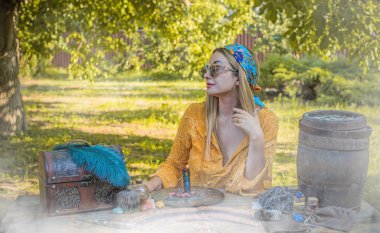 Çingene ruhu sihirli şeyleri olan Boho kadını, mumlar, sahadaki diğerleri, yaşam tarzı, öngörü, Cadılar Bayramı için kostüm fikirleri.