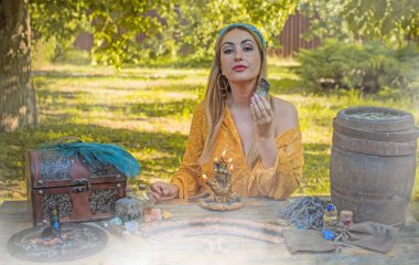 Çingene ruhu sihirli şeyleri olan Boho kadını, mumlar, sahadaki diğerleri, yaşam tarzı, öngörü, Cadılar Bayramı için kostüm fikirleri.