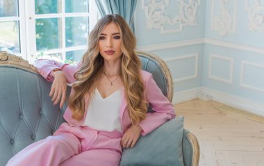 Pembe iş kostümlü bir kadın, modaya uygun trendler. Dolabın ayrıntıları