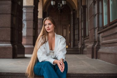 Gençlik konsepti. Güzel güzel Slav güzeli, uzun sarı saçlı, şehir sokağındaki kız, açık hava portresi.