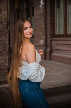 Gençlik konsepti. Güzel güzel Slav güzeli, uzun sarı saçlı, şehir sokağındaki kız, açık hava portresi.