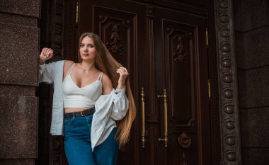 Gençlik konsepti. Güzel güzel Slav güzeli, uzun sarı saçlı, şehir sokağındaki kız, açık hava portresi.