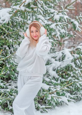 Beyaz yünlü kostüm, spor giysi ve kabarık kulaklar içinde sevimli bir kız.