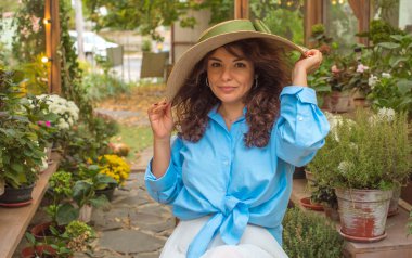 Mavi tişörtlü, beyaz etekli, açık hava resimli güzel bir Avrupalı yarı Latin kadın. 