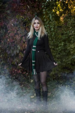 Büyücü okulu, büyülü sonbahar atmosferinde öğrenci, yeşil ve gümüş renkler. Cadılar Bayramı zamanı, maskeli balo