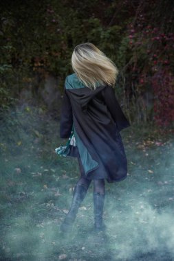 Büyücü okulu, büyülü sonbahar atmosferinde öğrenci, yeşil ve gümüş renkler. Cadılar Bayramı zamanı, maskeli balo