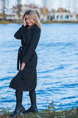 Siyah yün ceketli sarı saçlı kadın ve altın atkı, kadınlar için moda, gerçek açık hava fotoğrafı.