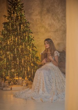 Yeni yıl atmosferi. Vintage elementler ve dekorasyon. Ortaçağ kıyafetleriyle kutlama yapan bir kadın, etrafta mumlar, havada sihir