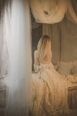 Beyaz dantel elbiseli kadın. Eski yatak odasındaki Avrupalı sarışın kadının şehvetli fotoğrafı. Moda konsepti