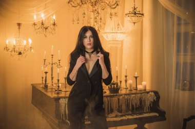 Efsanevi akşam atmosferinde siyah uzun saçlı, siyah elbiseli zarif bir kadın.