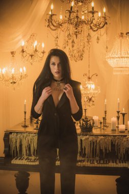 Efsanevi akşam atmosferinde siyah uzun saçlı, siyah elbiseli zarif bir kadın.