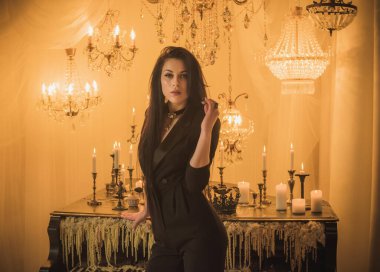 Efsanevi akşam atmosferinde siyah uzun saçlı, siyah elbiseli zarif bir kadın.