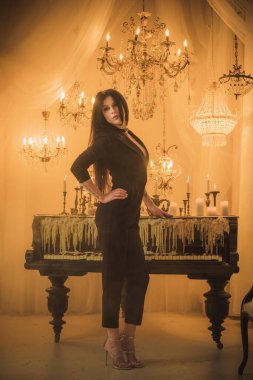 Efsanevi akşam atmosferinde siyah uzun saçlı, siyah elbiseli zarif bir kadın.