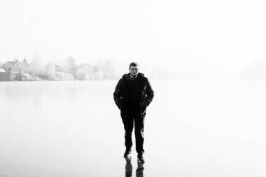 Kış sisi ve buz zemininde duran yalnız bir adamın silueti. Psikoloji kavramı, adam bir şeyler düşünüyor.