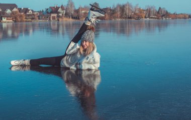 Buzda kayan bir kadın, numaralar ve hareketler yapıyor. Gölde kış güneşli bir gün. Etkin yeniden yaratma