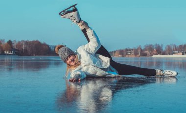 Buzda kayan bir kadın, numaralar ve hareketler yapıyor. Gölde kış güneşli bir gün. Etkin yeniden yaratma