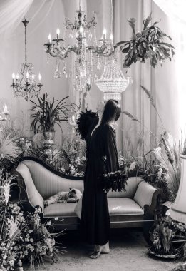 Boho 'nun klasik Fransız atmosferinde siyah cüppeli tüylü bir kadın. Modern kadın yaşam tarzı.. 