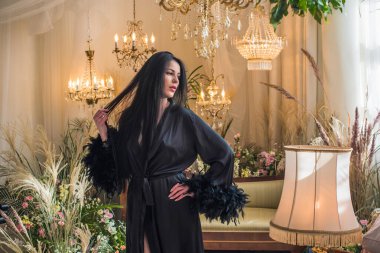 Boho 'nun klasik Fransız atmosferinde siyah cüppeli tüylü bir kadın. Modern kadın yaşam tarzı.. 