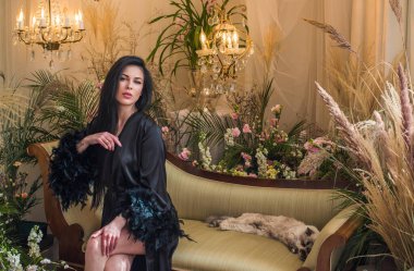 Boho 'nun klasik Fransız atmosferinde siyah cüppeli tüylü bir kadın. Modern kadın yaşam tarzı.. 