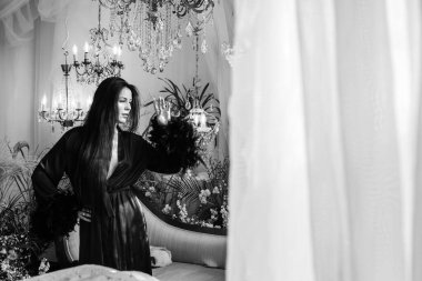 Boho 'nun klasik Fransız atmosferinde siyah cüppeli tüylü bir kadın. Modern kadın yaşam tarzı.. 