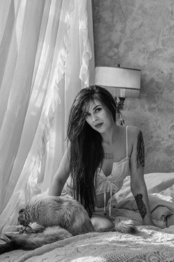 Gün ışığında yumuşak bir Fransız sabahı. Beyaz yatakta uyuyan pijamalı modern bir kadın.