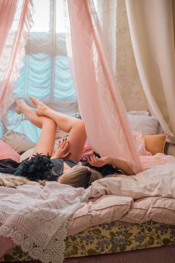 Klasik Fransız atmosferinde Peignoir giymiş bir kadın. Tüylü siyah ipek bornozlu Avrupalı sarışın kadının şehvetli fotoğrafı. Moda konsepti