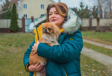 Küçük bir köpeği olan olgun bir kadın. Evcil hayvanlı yaşam tarzı