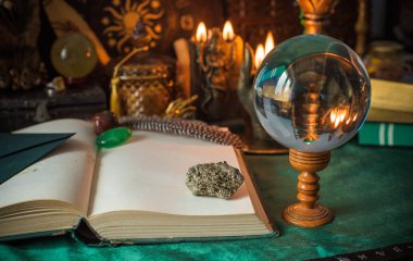 Parlayan mumların, antik tarot kartlarının, kristal kürenin ve sihirli ayin aletlerinin yer aldığı güzel düzenlenmiş bir cadı sunağı sahnesi. Bu atmosferik bileşim mistik enerjinin, ruhani uygulamanın ve esrarengiz zarafetin özünü çağrıştırıyor.