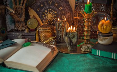 Parlayan mumların, antik tarot kartlarının, kristal kürenin ve sihirli ayin aletlerinin yer aldığı güzel düzenlenmiş bir cadı sunağı sahnesi. Bu atmosferik bileşim mistik enerjinin, ruhani uygulamanın ve esrarengiz zarafetin özünü çağrıştırıyor.